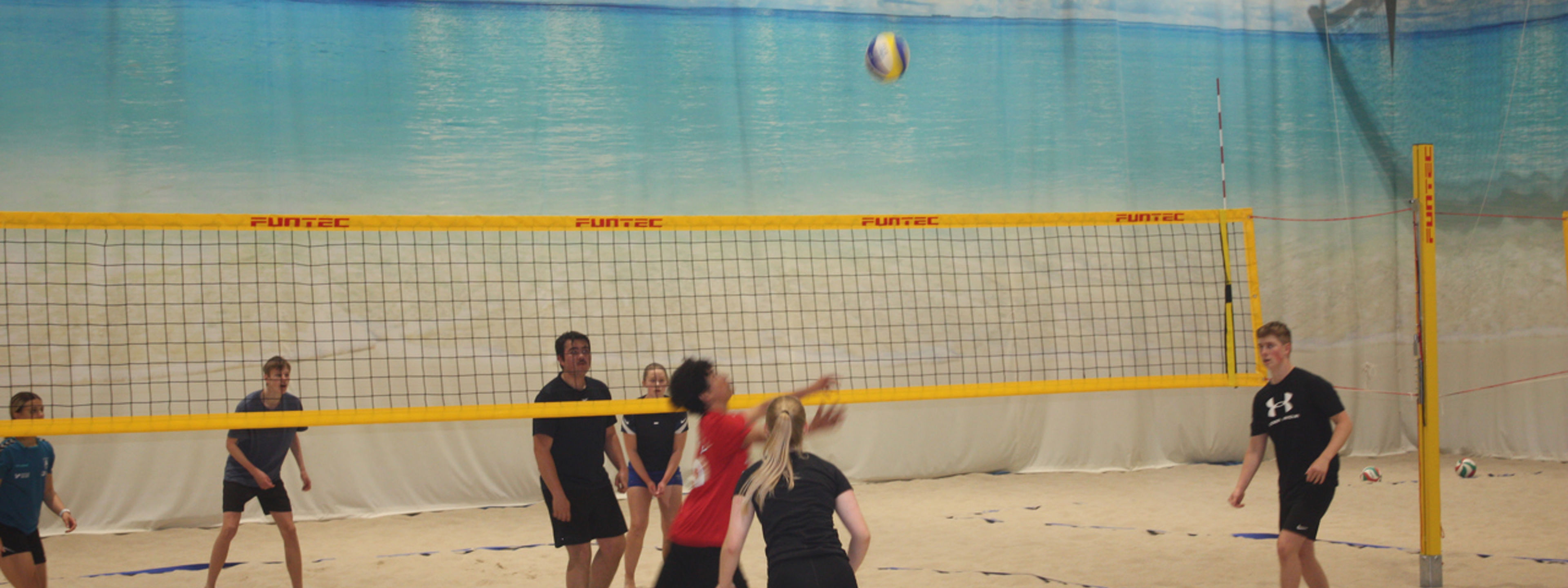 Elevar som spiller sandvolleyball
